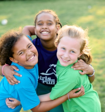 Three Girls on the Run participants smiles with their arms around each other